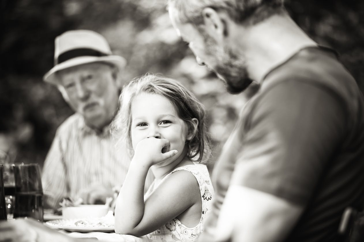 Young child, father and grandfather enjoying outdoor lunch